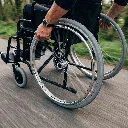 Person_moving_wheelchair_on_path_202608241332.webp